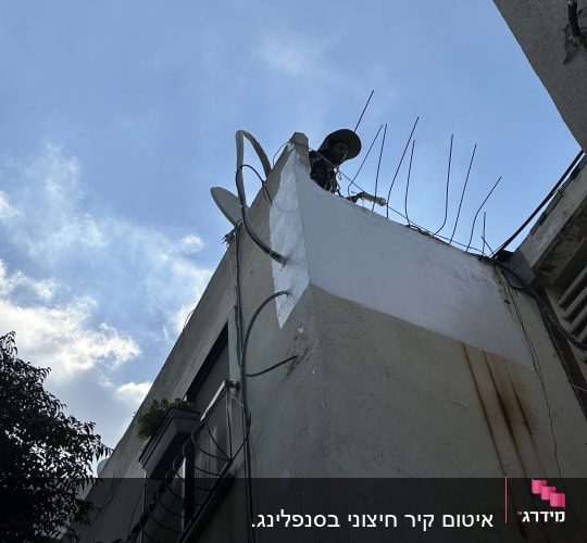 אדם עם כובע על גג עם אנטנות